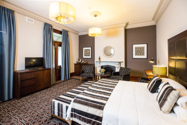 a comfortable king size bed and luxury furnitures inside Avonmore on the Park's king suite