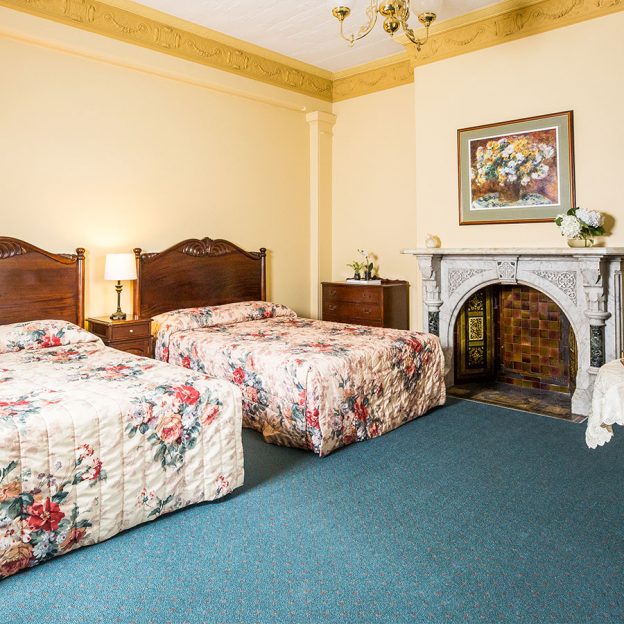 twin beds and stunning wall decors featured in one of Avonmore on the Park's rooms